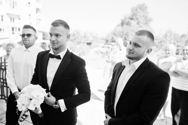 El novio con el ramo de boda de las orquídeas blancas a mano con el novio —  Fotos de Stock