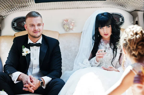 Удивительная свадебная пара внутри элегантного лимузина в их шикарном — стоковое фото