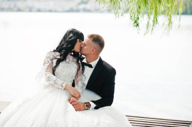 Harika Düğün çifti bankta oturan Gölü arka plan.