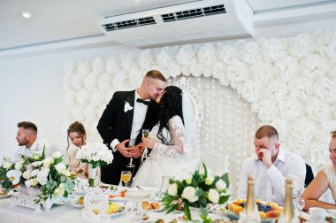 Bardak şampanya masada yakınındaki öpüşme ile çift düğün 