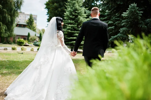 Vue arrière du couple de mariage à pied au jardin de la cour . — Photo