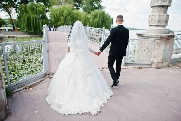Visão traseira do casal de casamento andando na ponte para a ilha do amor . — Fotografia de Stock