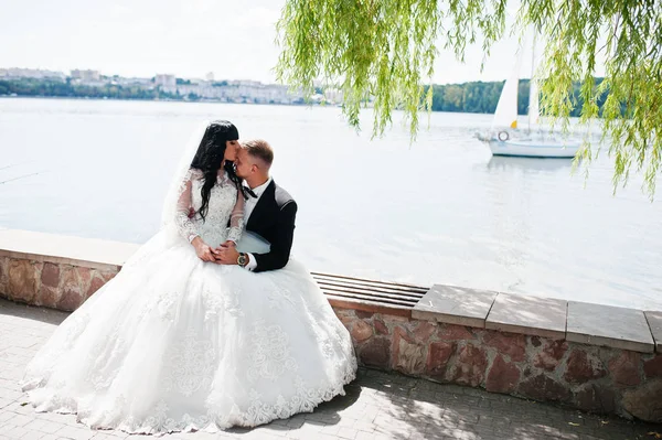 Maravilhoso casamento casal sentado no banco de fundo vela shi — Fotografia de Stock