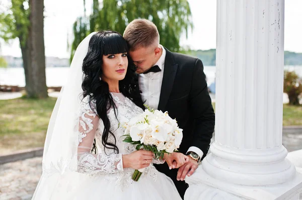 Casal magnífico perto de colunas brancas de arco de amor . — Fotografia de Stock