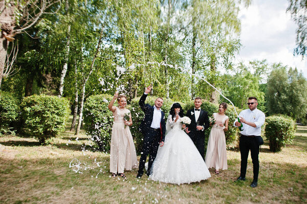 Stylish wedding couple, groomsman and bridesmaids with champagne