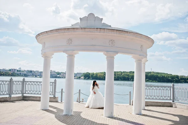 Panna Młoda w białe kolumny pomnik tle jeziora na słoneczny ślubne — Zdjęcie stockowe