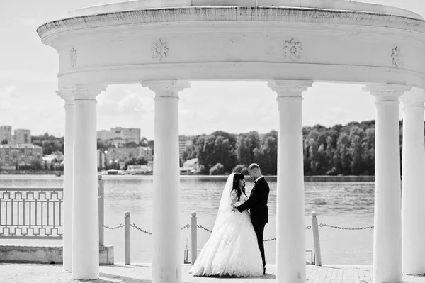 Excelente pareja de boda bajo columnas blancas monumento fondo la —  Fotos de Stock