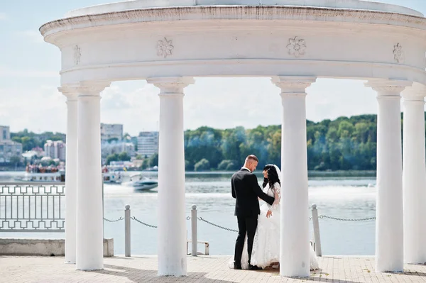 Pompás esküvői pár alatt fehér oszlopok emlékmű háttér la — Stock Fotó