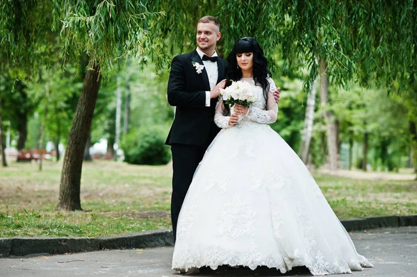 Para ślub przemiły zatrzymać w przytulanie na park tło wierzby — Zdjęcie stockowe