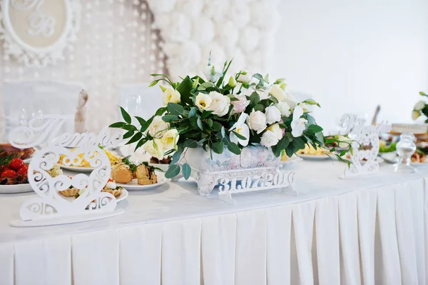 Fiori su tavolo nuziale di novelli sposi. Cuori decorativi e segno — Foto Stock