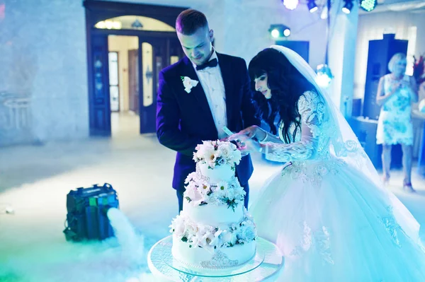 Impressionantes recém-casados na festa de casamento com bolo de casamento no colourfu — Fotografia de Stock