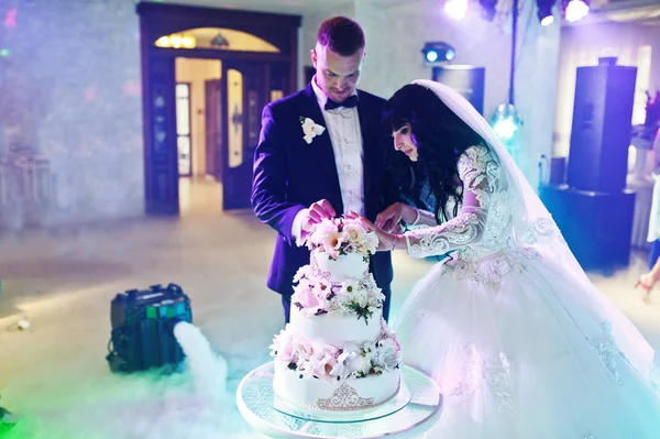 Awesome jonggehuwden op huwelijksfeest met bruidstaart op colourfu — Stockfoto
