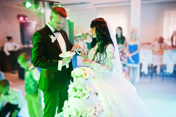 令人敬畏的新婚夫妇在婚礼上党与 colourfu 婚礼蛋糕 — 图库照片
