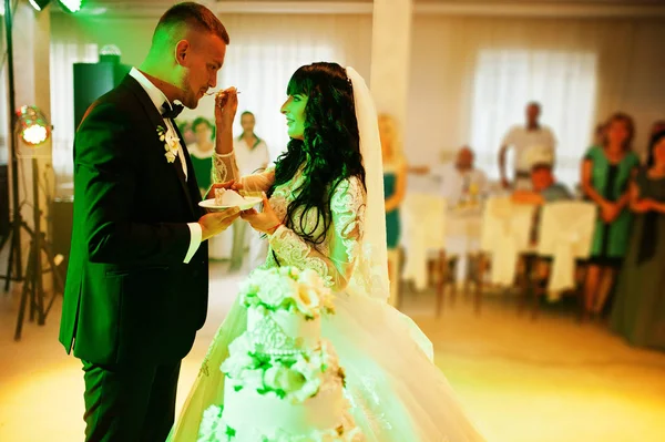 Impressionantes recém-casados na festa de casamento com bolo de casamento no colourfu — Fotografia de Stock