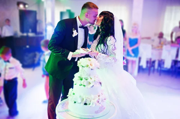 Impressionantes recém-casados na festa de casamento com bolo de casamento no colourfu — Fotografia de Stock