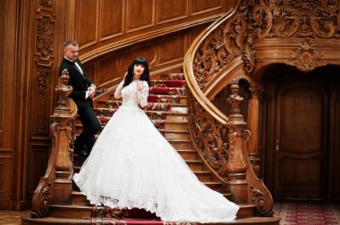 Muhteşem düğün çift zengin Sarayı'nda büyük Ahşap merdiven üzerinde.