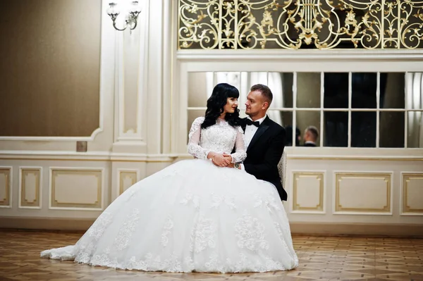 Magnífico casal de casamento sentado na cadeira no quarto real com m — Fotografia de Stock