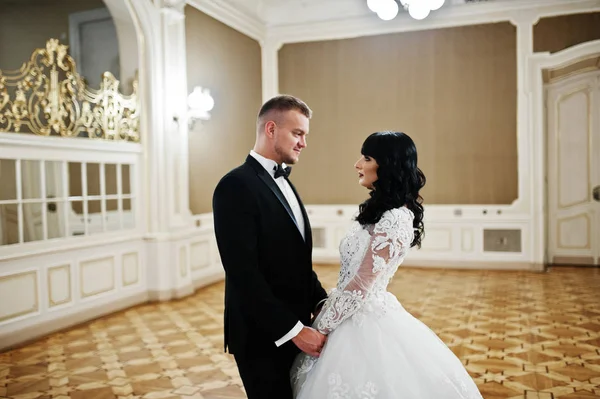 Magnificent wedding couple on royal room with many mirrors.
