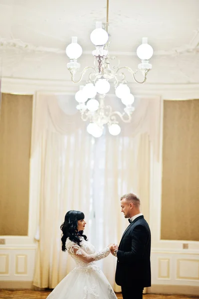 Reiches Hochzeitspaar im königlichen Zimmer mit goldener Lampe an der Decke — Stockfoto