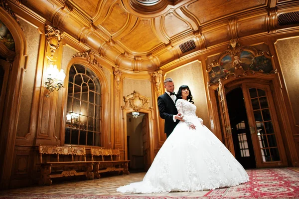 Ehrfürchtiges Hochzeitspaar drinnen reiche königliche Zimmer mit klassischem Holz — Stockfoto