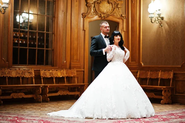 Ehrfürchtiges Hochzeitspaar drinnen reiche königliche Zimmer mit klassischem Holz — Stockfoto