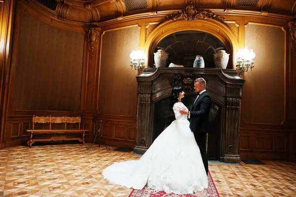 Königliches Hochzeitspaar im Hintergrund großer Steinkamin im Palast — Stockfoto