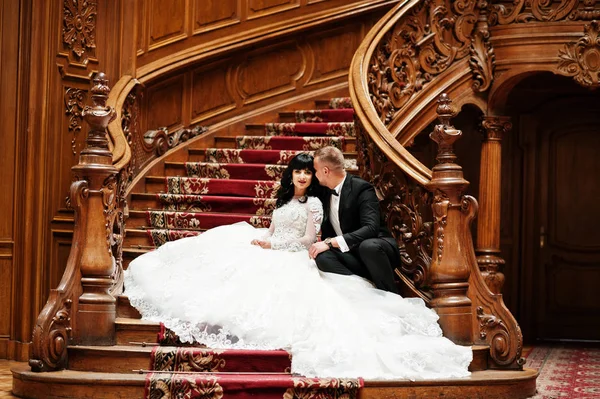 Encantadora pareja de boda sentada en escaleras de madera ricas en gran r —  Fotos de Stock