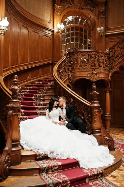 Büyük r zengin ahşap merdivenlerde oturan büyüleyici Düğün çifti — Stok fotoğraf