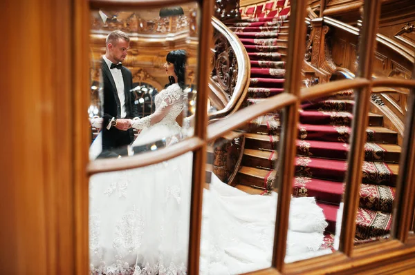 Hochzeitspaar im Spiegelhintergrund große reiche Treppen. — Stockfoto