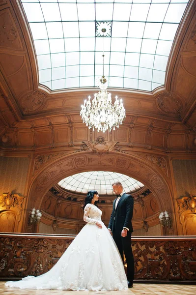 Prachtige bruiloft paar jonggehuwde op rijke houten Koninklijk Paleis. — Stockfoto