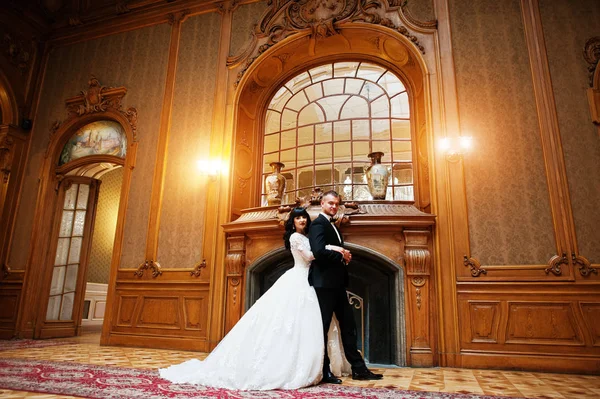 Königliches Hochzeitspaar im Hintergrund großer Steinkamin im Palast — Stockfoto