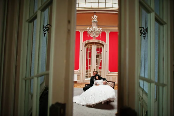 Стильна весільна пара на червоній кімнаті в палаці . — стокове фото