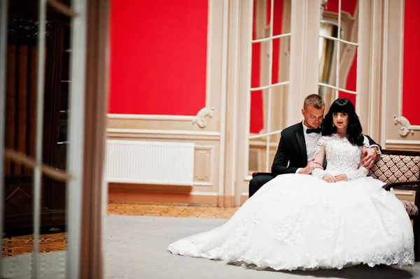 Elegante pareja de boda en habitación roja en el palacio . —  Fotos de Stock