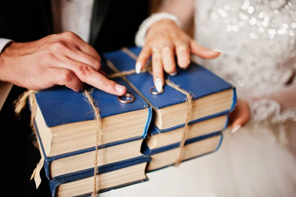 Close up wedding rings on old books at library on hands of newly — Stock Photo, Image