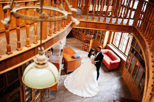 Hochzeitspaar auf alter Holzbibliothek am Hochzeitstag. — Stockfoto