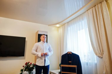 Düğün gününde gömlek giymiş genç güçlü adam. Sabah damat