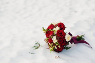 Kar üzerinde beyaz ve kırmızı gül buketi düğün.