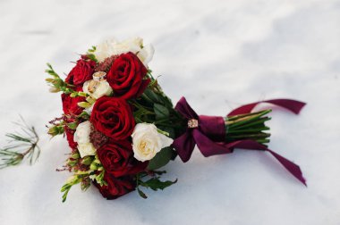 Kar üzerinde beyaz ve kırmızı gül buketi düğün.
