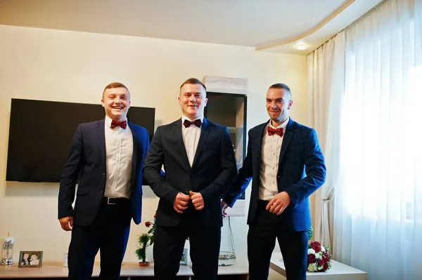 Groom with best mans at his wedding day on room.