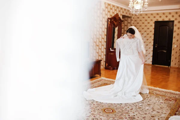 Симпатична брюнетка наречена на шовковому платті з весільним платтям на руках . — стокове фото