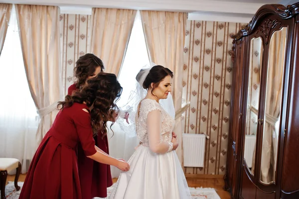 Duas damas de honra jovens e lindos no vestido vermelho desgaste noiva em ele — Fotografia de Stock