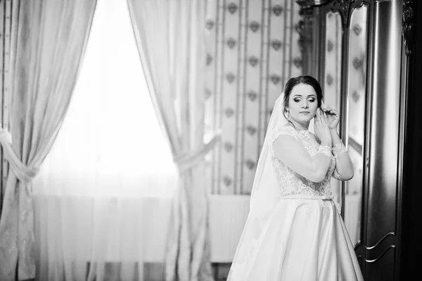Νεαρή μελαχρινή νύφη που θέτεται στο δωμάτιό της, κατά την ημέρα του γάμου. Μαύρο και — Φωτογραφία Αρχείου