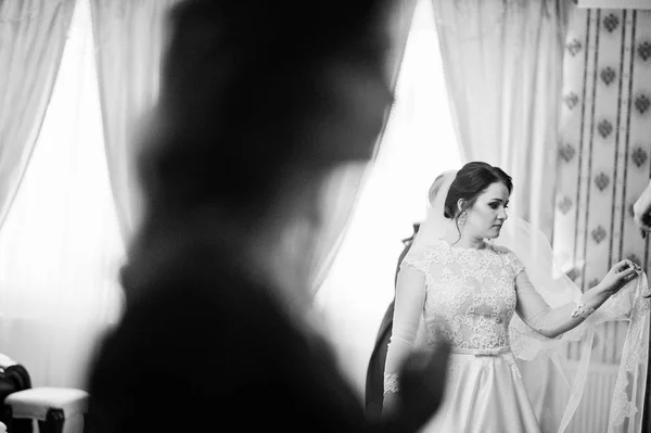 Молода брюнетка нареченої позувала на своїй кімнаті в день весілля. Чорний і — стокове фото