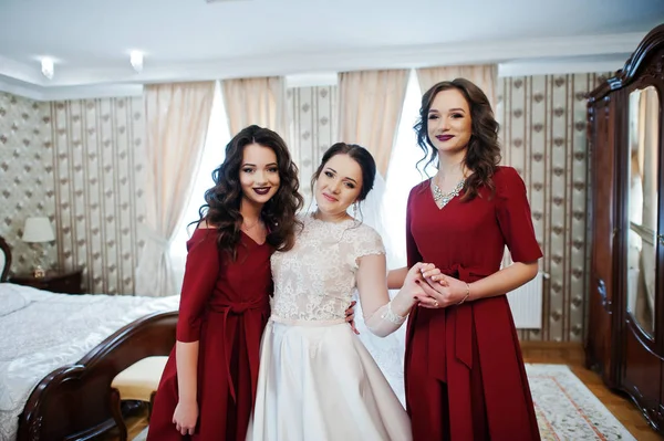 Braut mit zwei erstaunlichen Brautjungfern auf rotem Kleid posierte auf dem Zimmer bei — Stockfoto