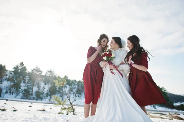 Bonitas damas de honor en vestidos rojos con novia en invierno soleado casado —  Fotos de Stock