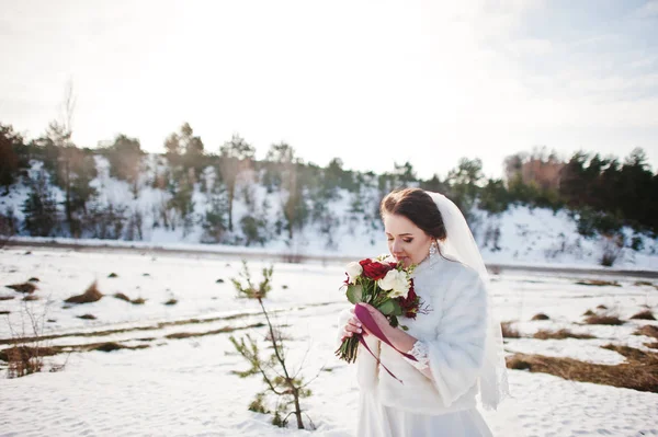 Ritratto di sposa bruna carina con bouquet su mani al gelo a — Foto Stock