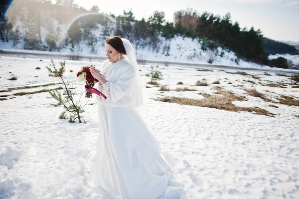 Ritratto di sposa bruna carina con bouquet su mani al gelo a — Foto Stock