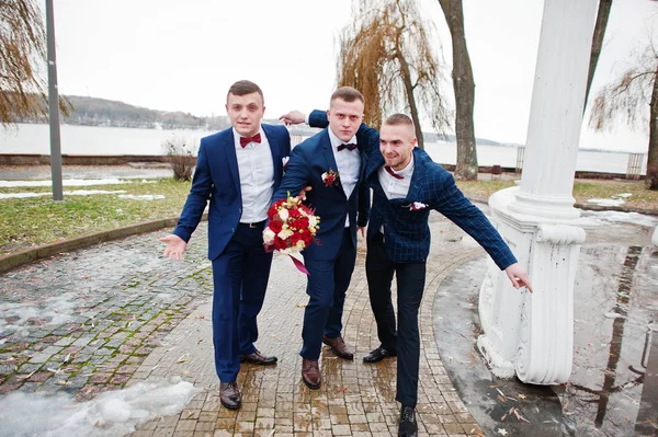Groom with best mans at cold winter wedding day.