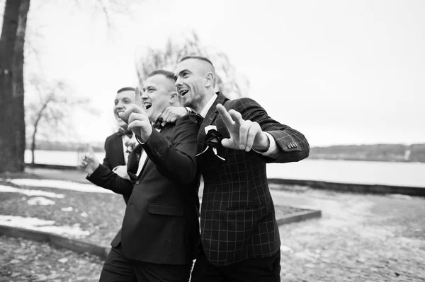 Groom with best mans at cold winter wedding day. Black and white