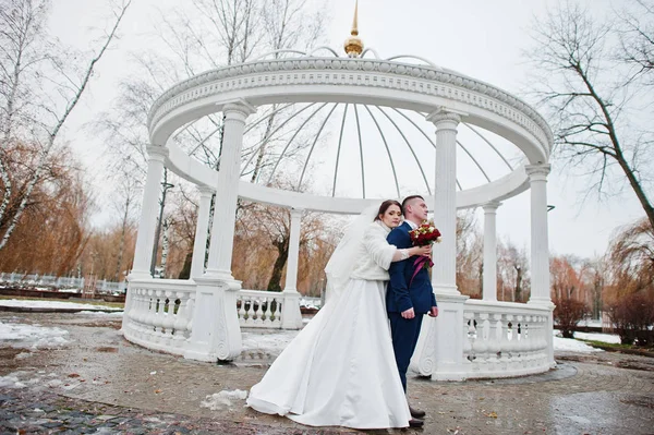 Smyslné svatební pár na pozadí bílého oblouku s sloupce za sloupec — Stock fotografie